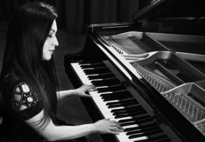 Black and White picture of Ella Anchor Playing Piano