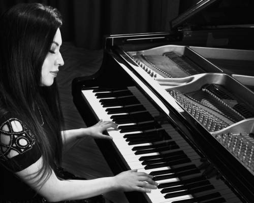 Black and White picture of Ella Anchor Playing Piano